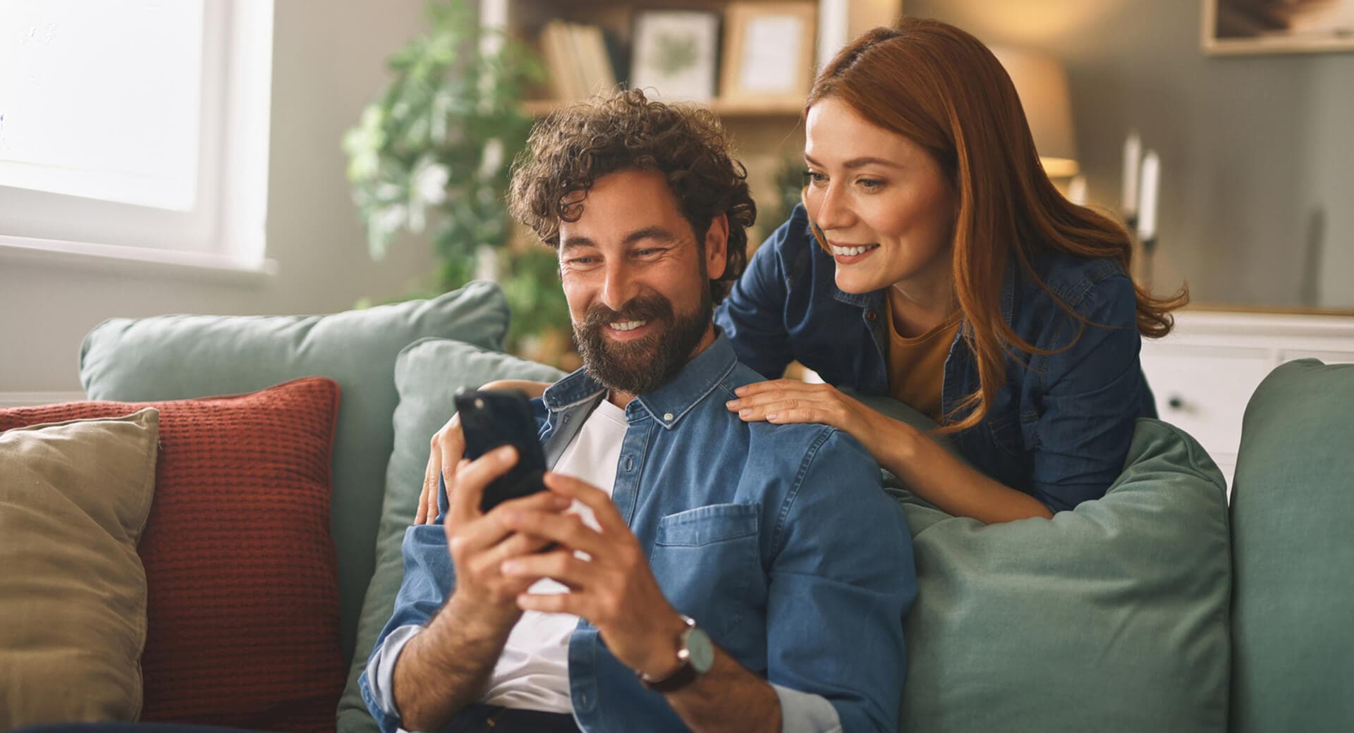Homem e mulher sorrindo olhando para o celular